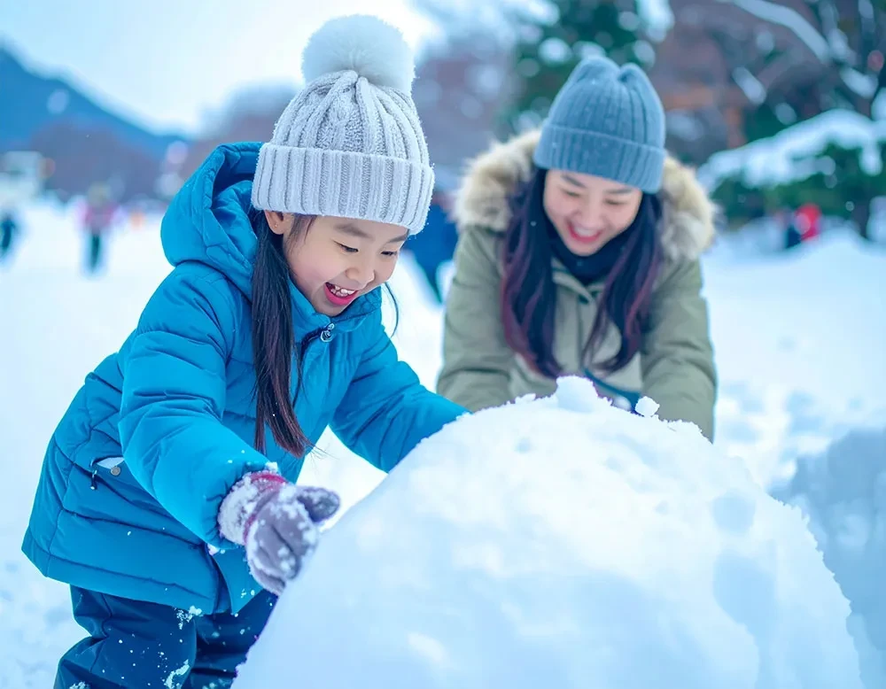 雪で遊ぶ子供と女性