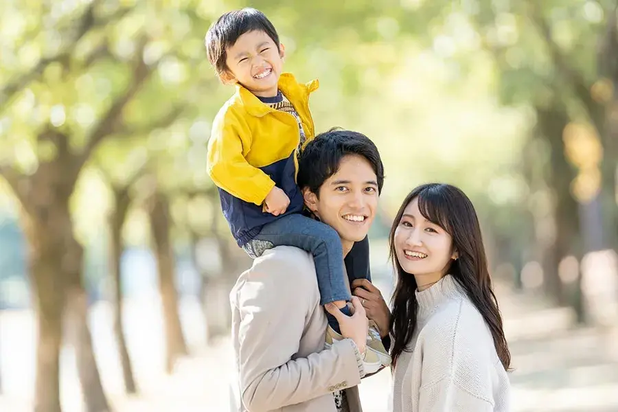 子供を肩車して歩く家族