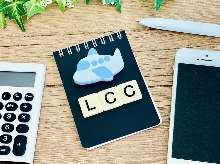 飛行機のおもちゃとLCCの文字、メモ帳など